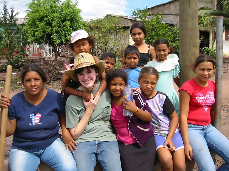 An AHH member and several students take a break from their work and pose for a photo.