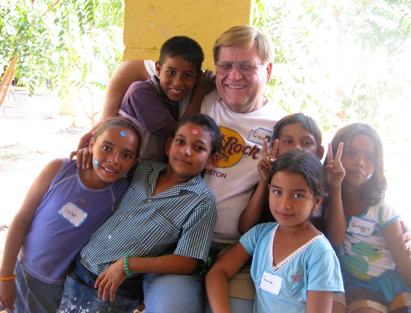 An AHH volunteer poses with a group of Honduran children during vacation Bible school.