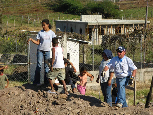 Children play near workers a construction site in Colonia Soidaridad