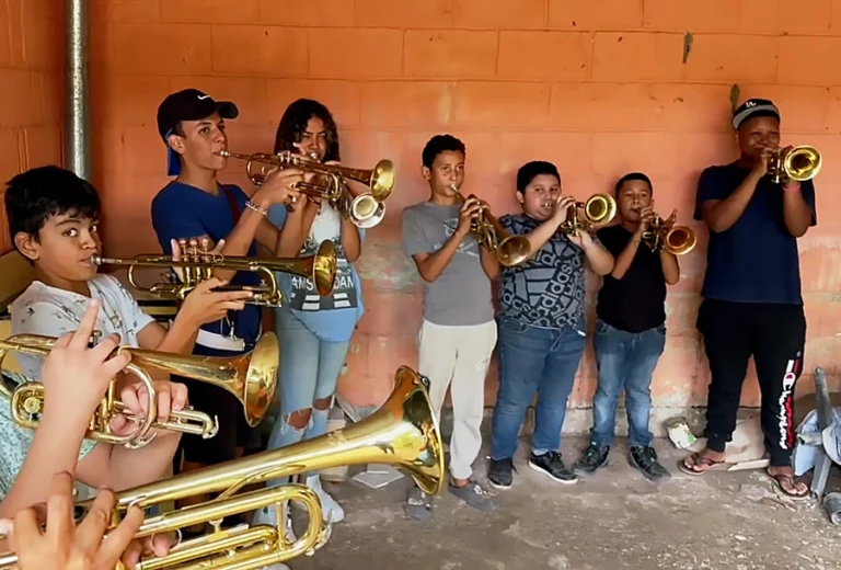 A group of middle school band students practice playing the trumpet.