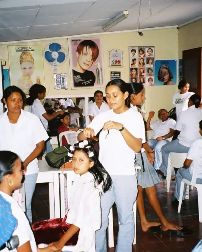 Several children receive haircuts and others wait their turn in a bustling hair salon in Honduras.