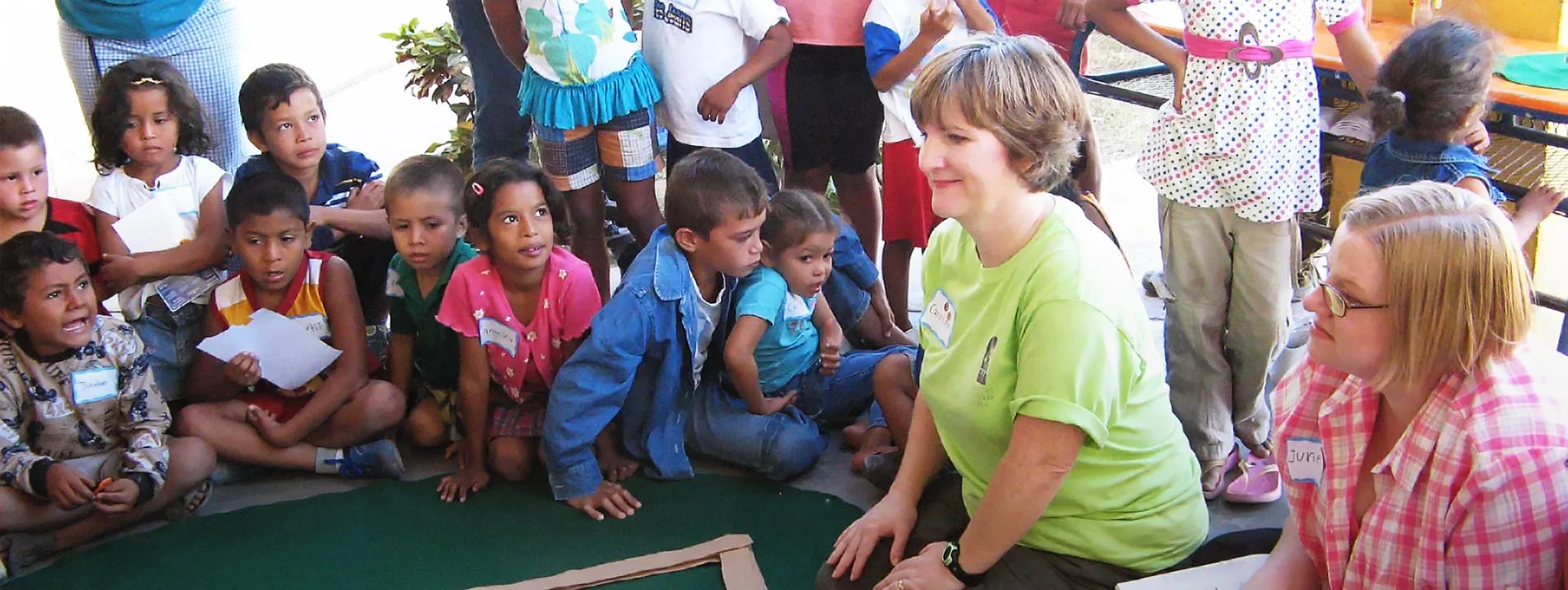 Students gather around around a camp instructor during vacation Bible school.