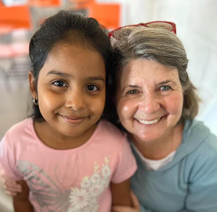 An AHH volunteer and young girl smile and pose for a photo during AHH's annual trip to Colonia Solidaridad.